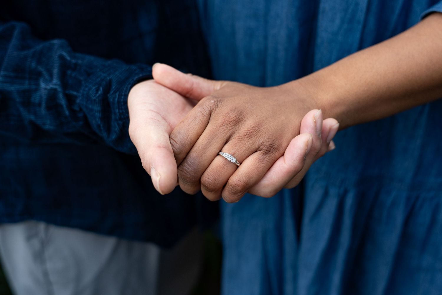 Close-up view of hands holding a traditional wooden chopstick rest in a Japanese dining setting.