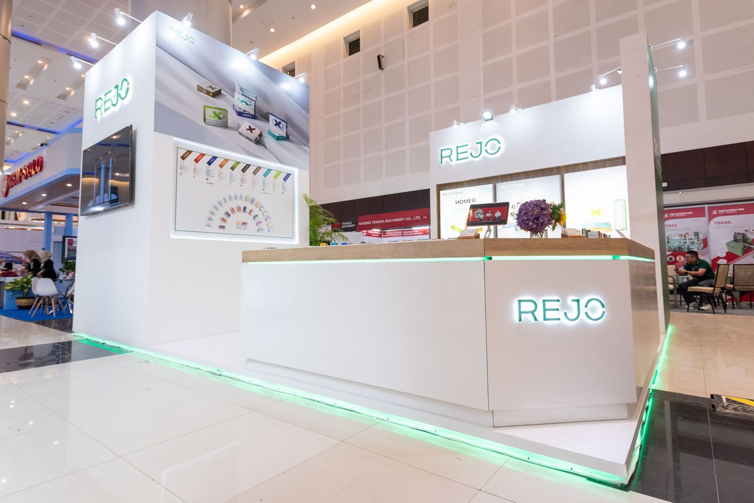 Modern white retail kiosk with glowing green LED trim and clean minimalist design in a shopping mall interior.