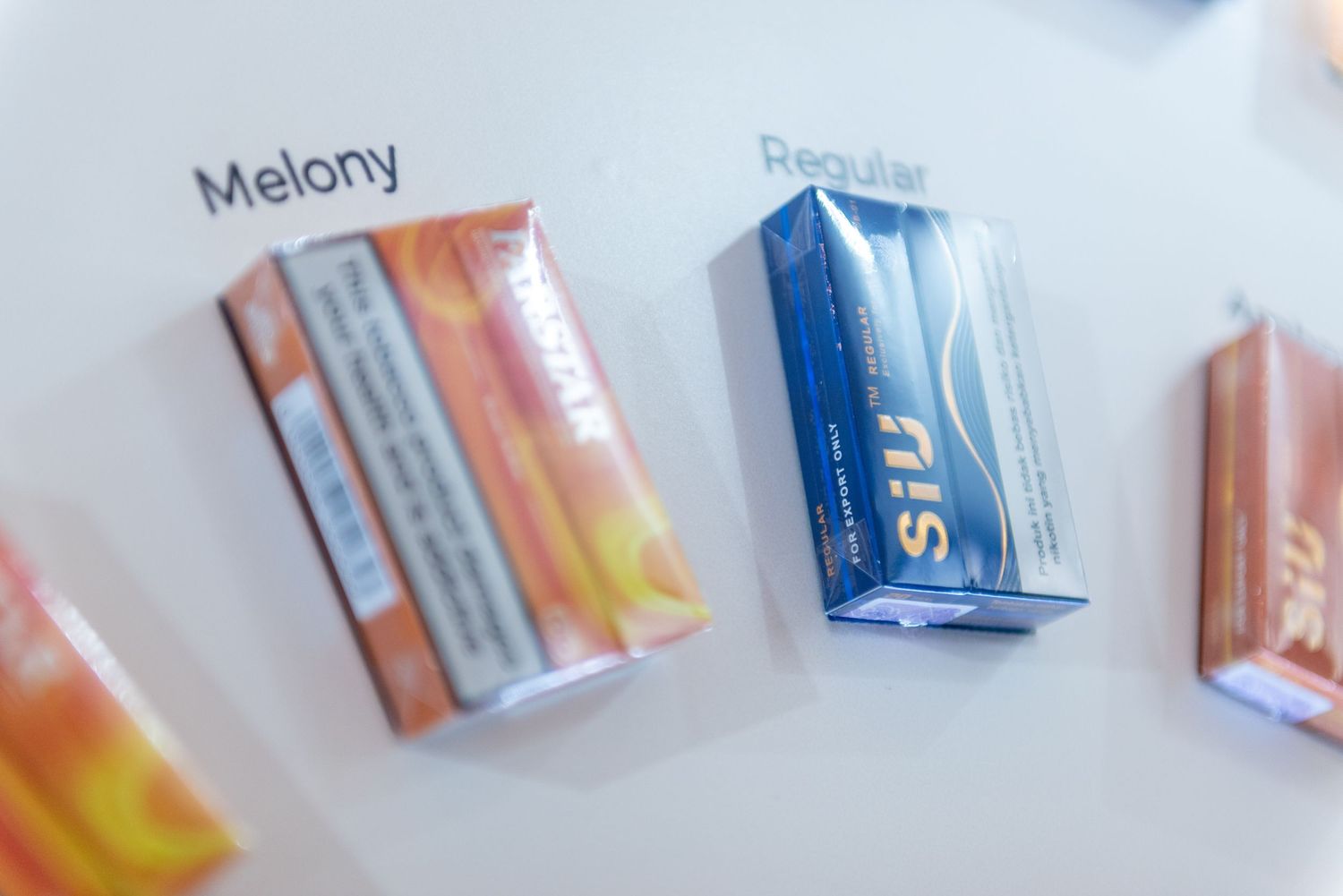 Colorful cigarette packs and boxes arranged in a row against a light background.