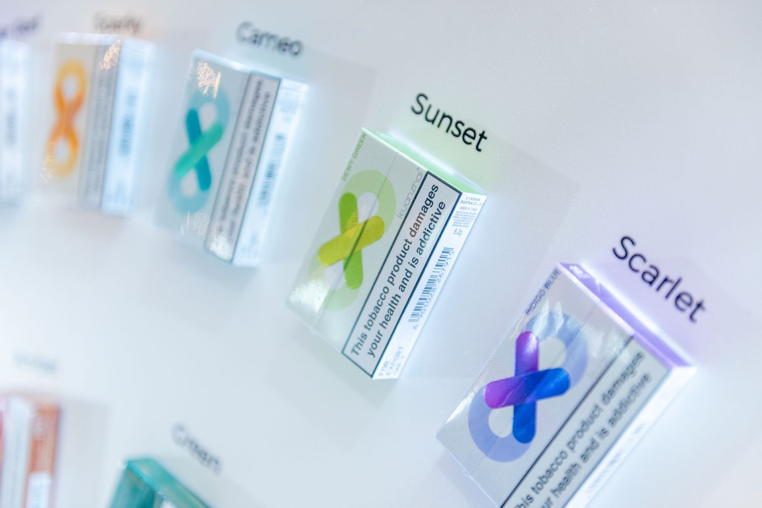 Colorful medical test kits with X-shaped markers displayed in a row with labels including Sunset and Scarlet.