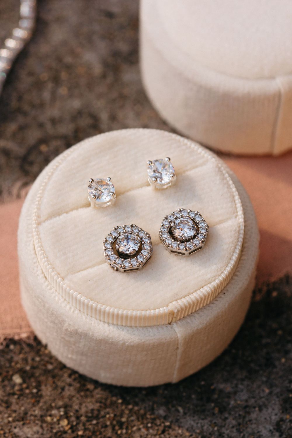 Close-up sequence of sparkling diamond engagement rings displayed on white textured ring holders.