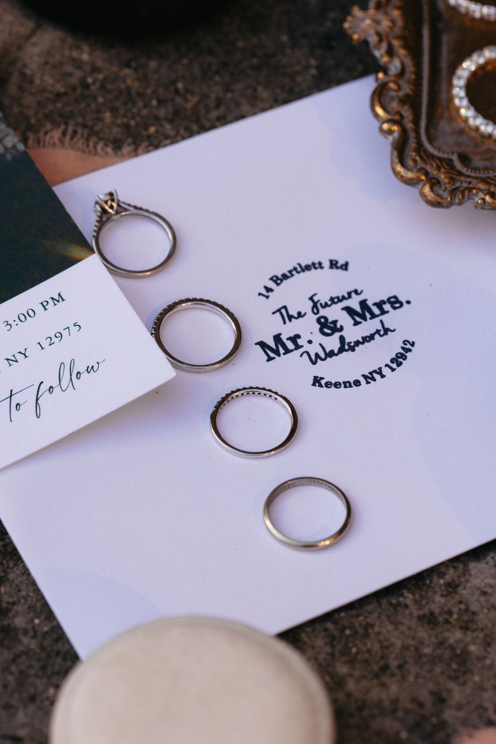 Four wedding rings arranged on white stationery with Mr. and Mrs. text visible.