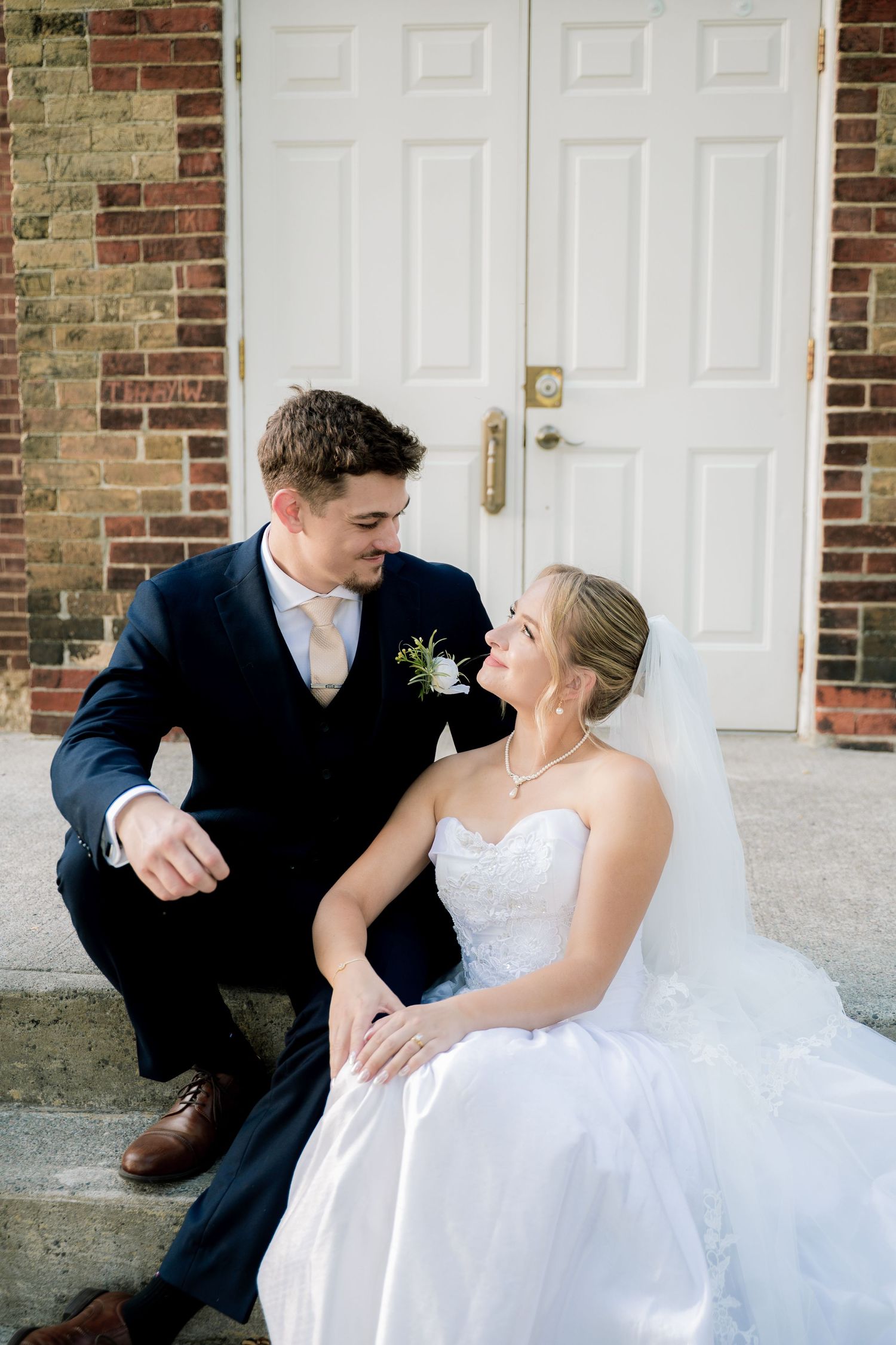 A romantic wedding photo sequence showing a couple in formal attire sitting together against a brick wall.