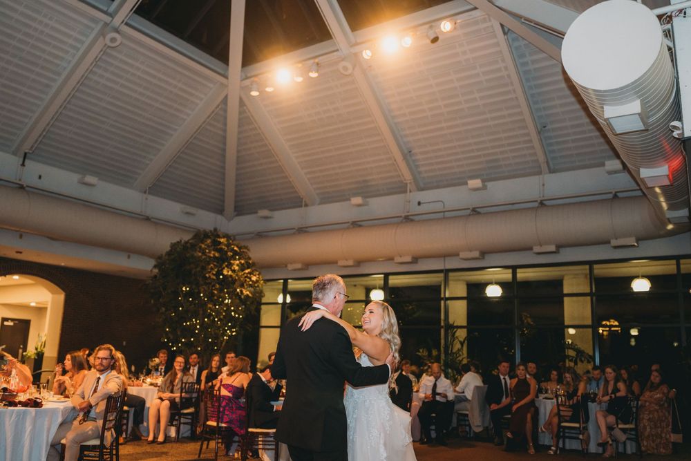 Wedding reception venue with white tent ceiling and hanging lanterns creating a romantic atmosphere.