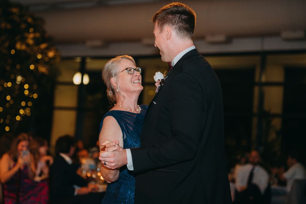 Wedding reception dance floor filled with guests celebrating under warm lighting.