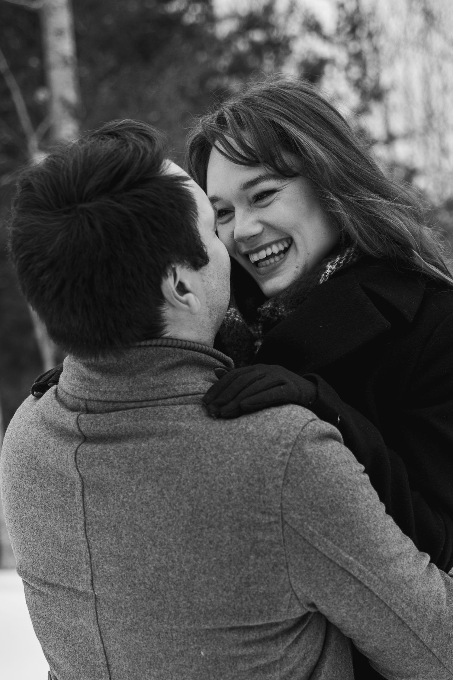 Black and white photo series showing a couple embracing and laughing together in a candid romantic moment.