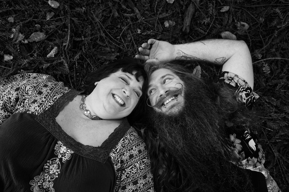 A black and white photo collage shows two people lying down and smiling together in various poses.
