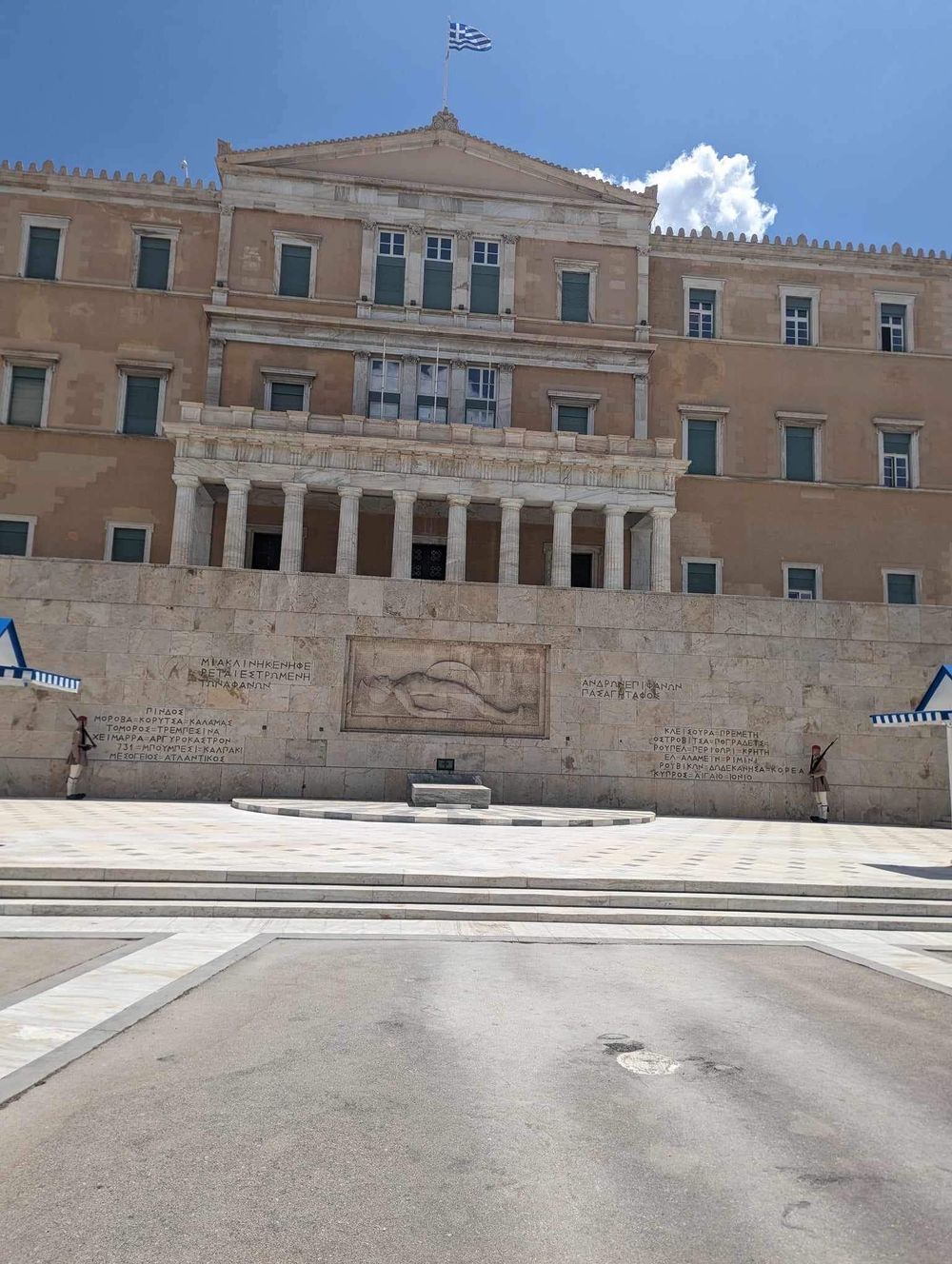 The Greek Parliament building in Athens with its neoclassical architecture and grand stone steps in Syntagma Square.