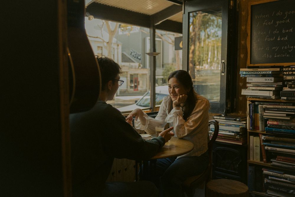 Warm sunlit cafe interior with bookshelves creating an intimate atmosphere.