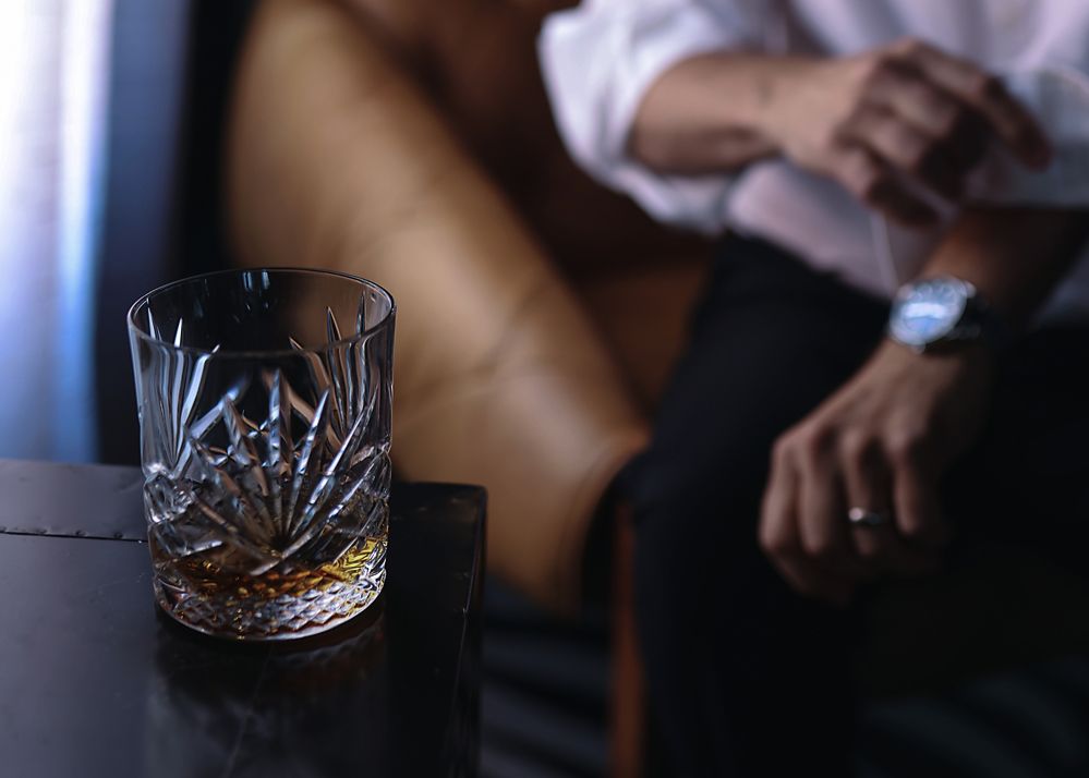 Cigarettes scattered on a dark wooden surface in moody lighting create an atmospheric still life composition.