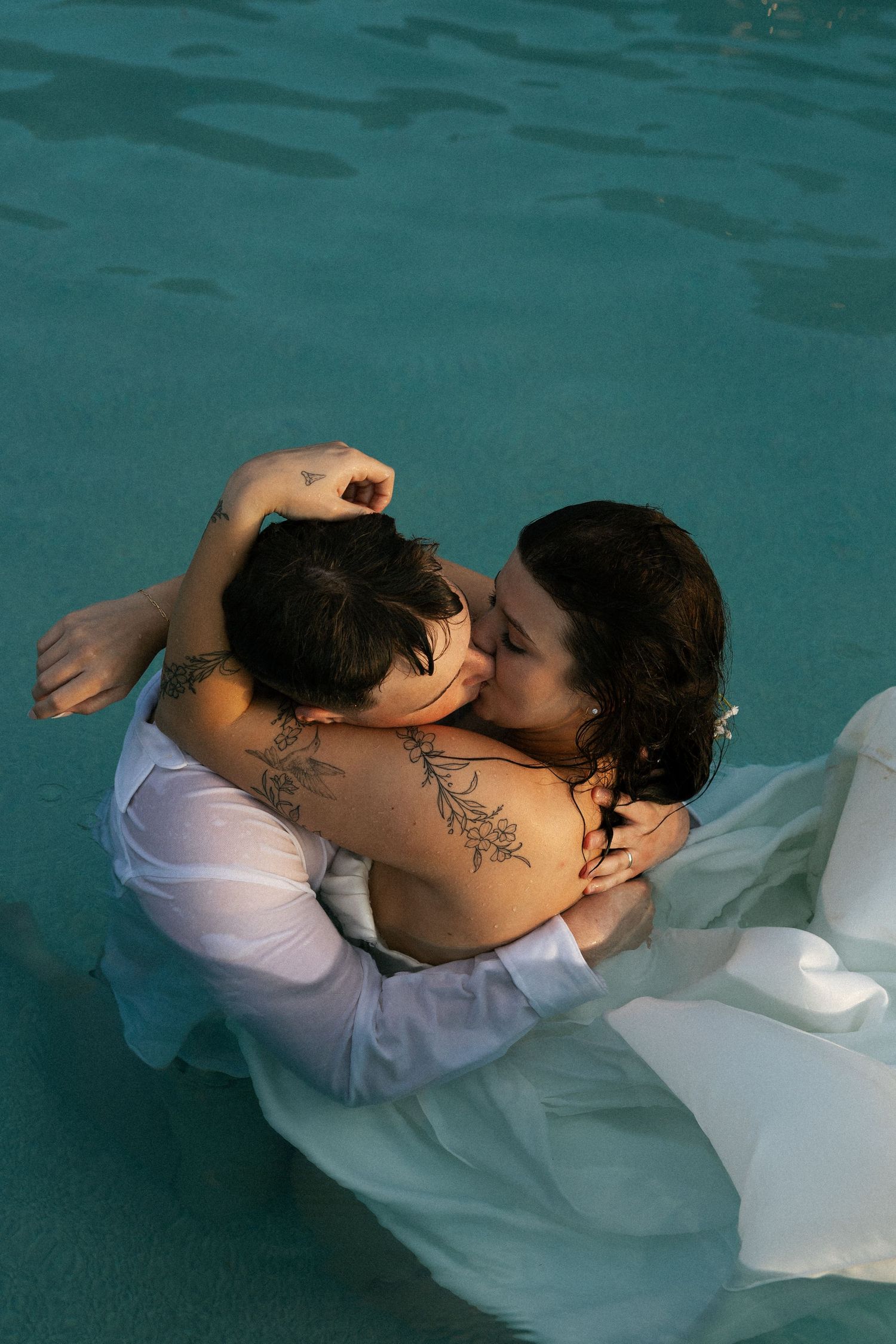 Newlyweds embrace while submerged in turquoise water during an intimate underwater photo session.Micro wedding, elopement, intentional celeb