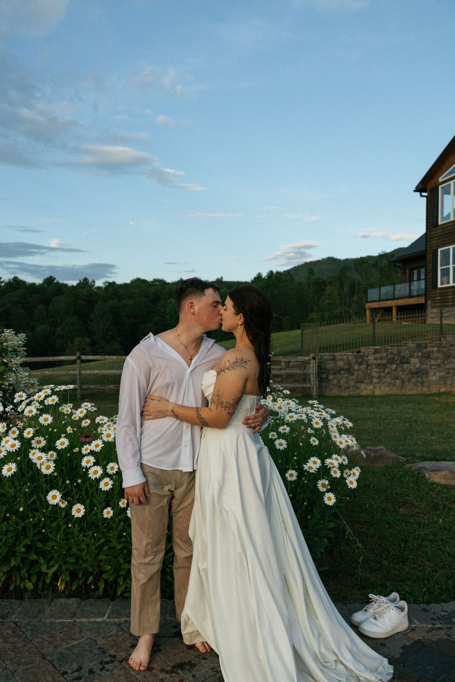 Romantic sunset photos in a garden with white daisies and a rustic building in the background.Micro wedding, elopement, intentional celebrat