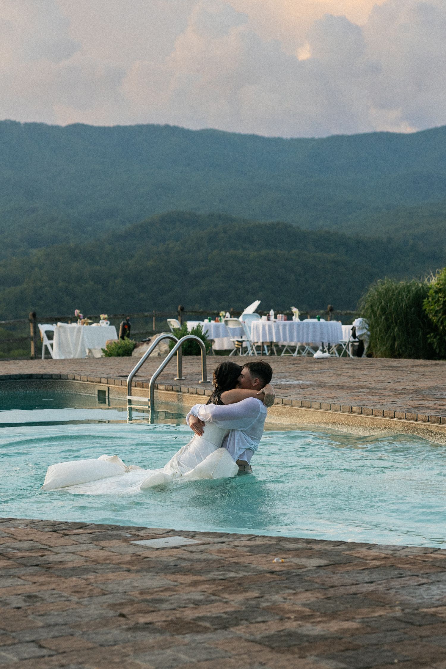 A sequence of photos showing someone gliding down a pool slide on an inflatable float at a mountain resort pool.
