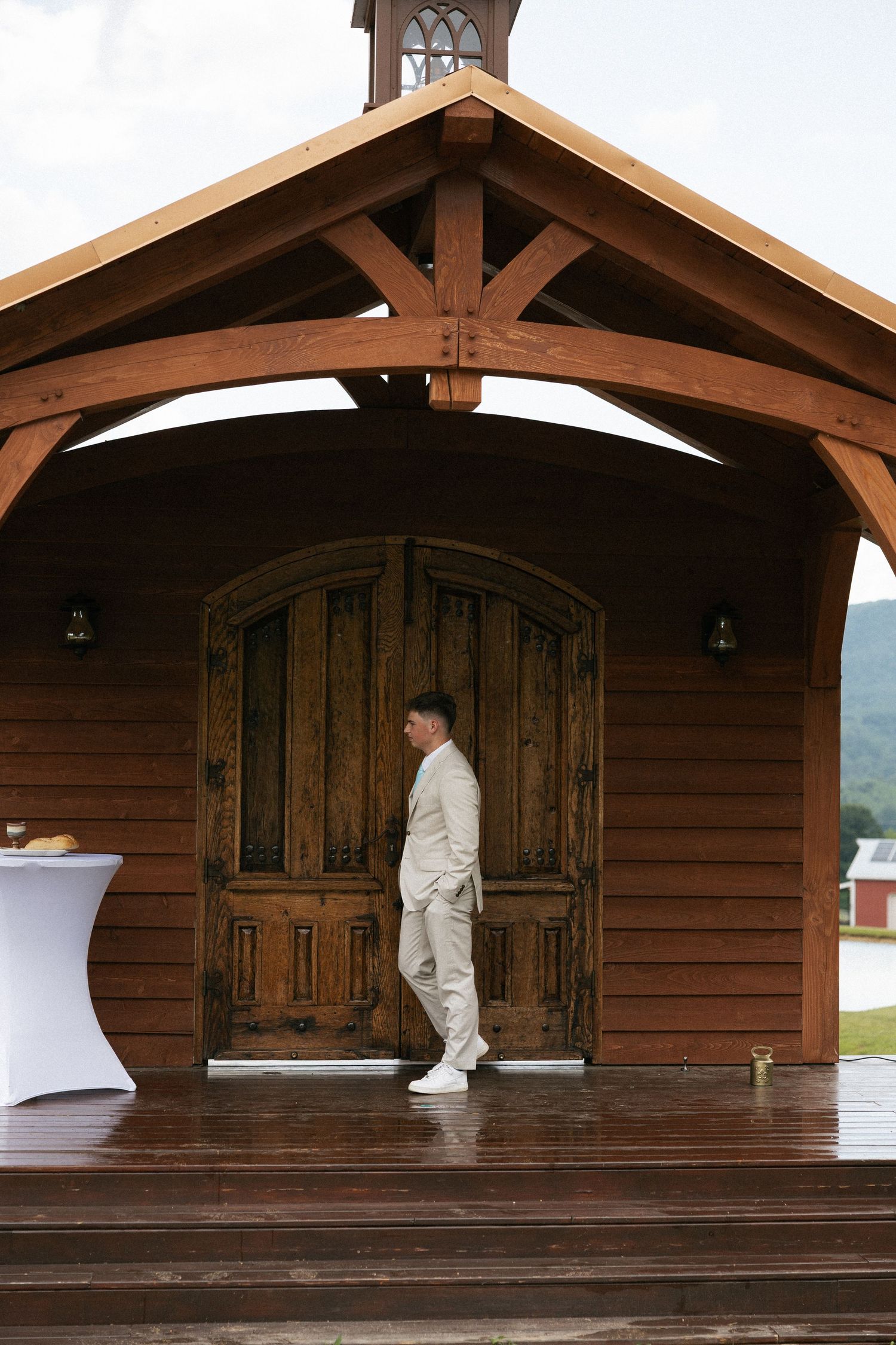 A rustic wooden chapel entrance with timber framing and large double doors on a covered porch.Micro wedding, elopement, intentional celebrat