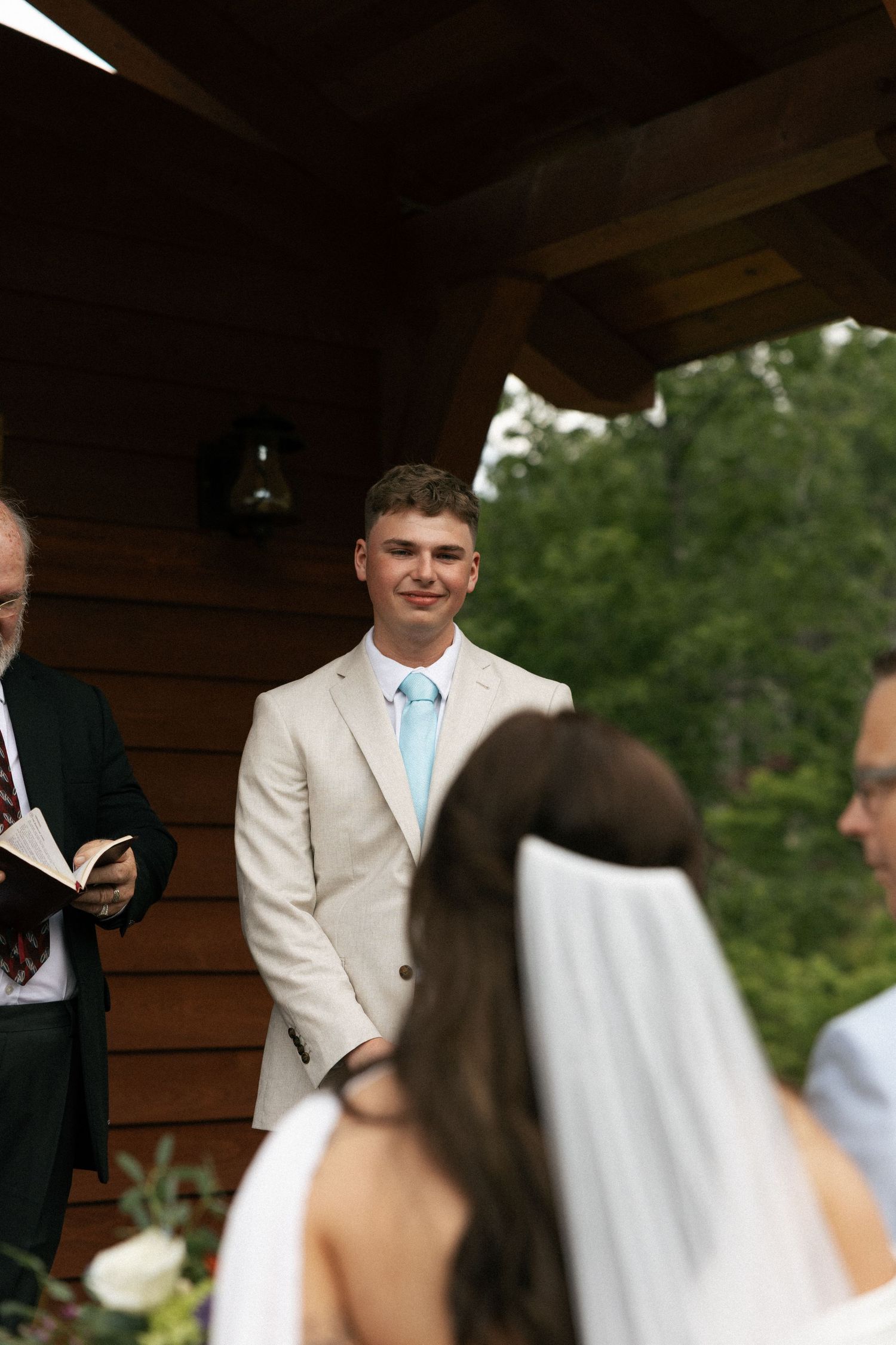 Wedding ceremony taking place under a wooden pavilion with natural lighting.Micro wedding, elopement, intentional celebration
