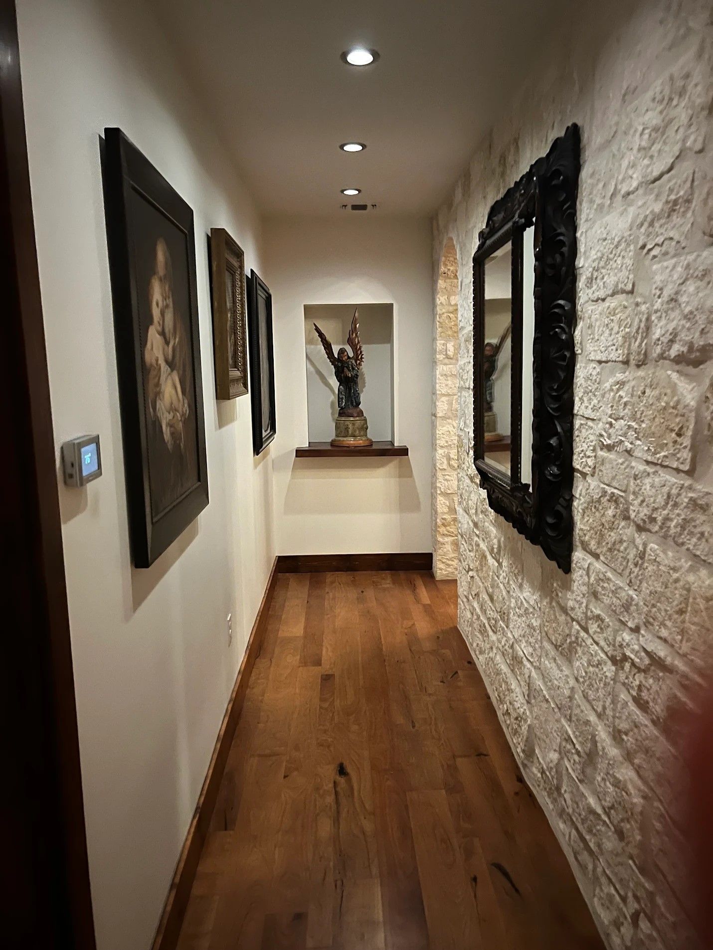 Rustic stone interior room with wrought iron chandeliers and dark wooden furniture creates a cozy medieval atmosphere.
