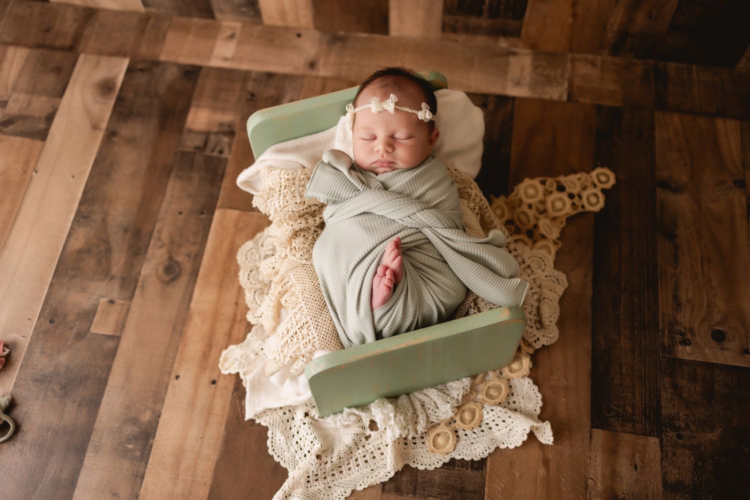 Natural newborn photography featuring a sleeping baby in a cozy studio environment