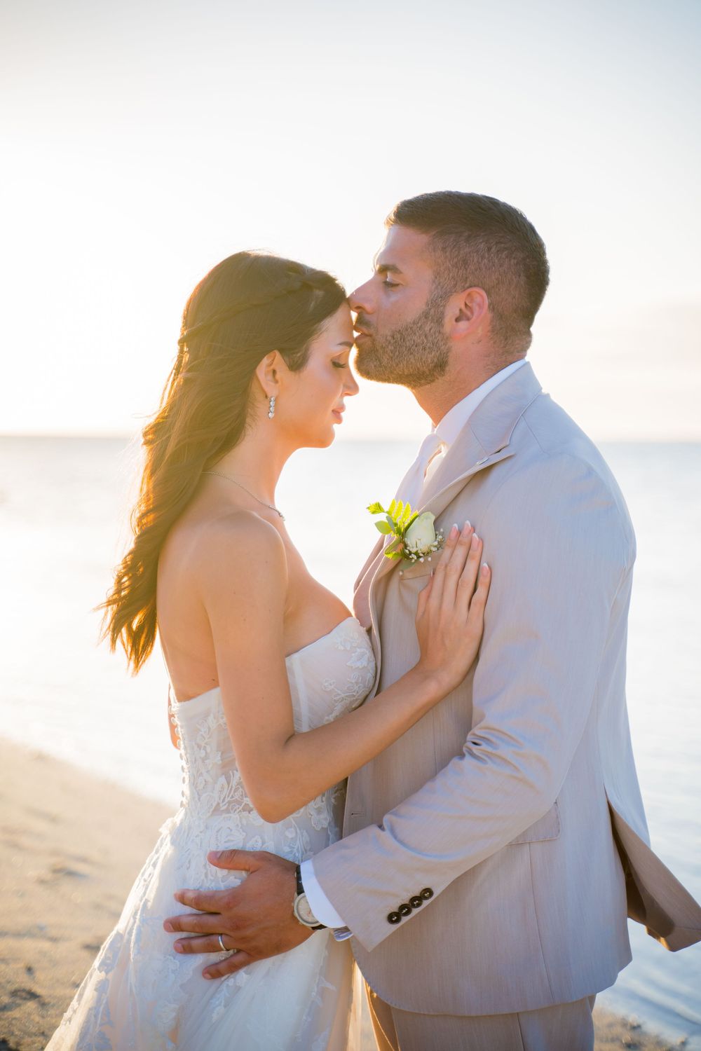 Romantic beach wedding portraits captured during golden hour.