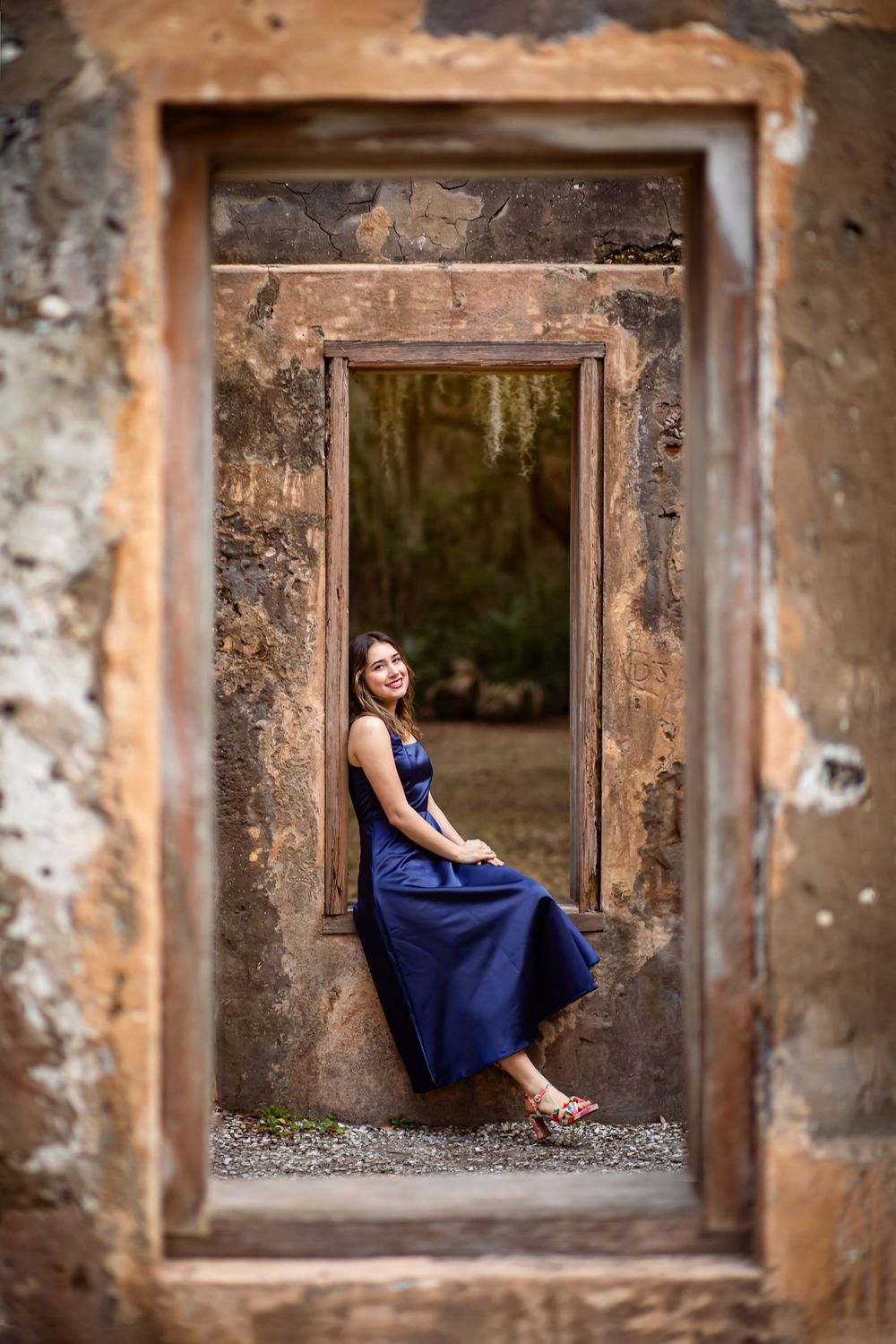 A sequence of photos showing a figure in a blue dress sitting in an old stone window frame against weathered walls.