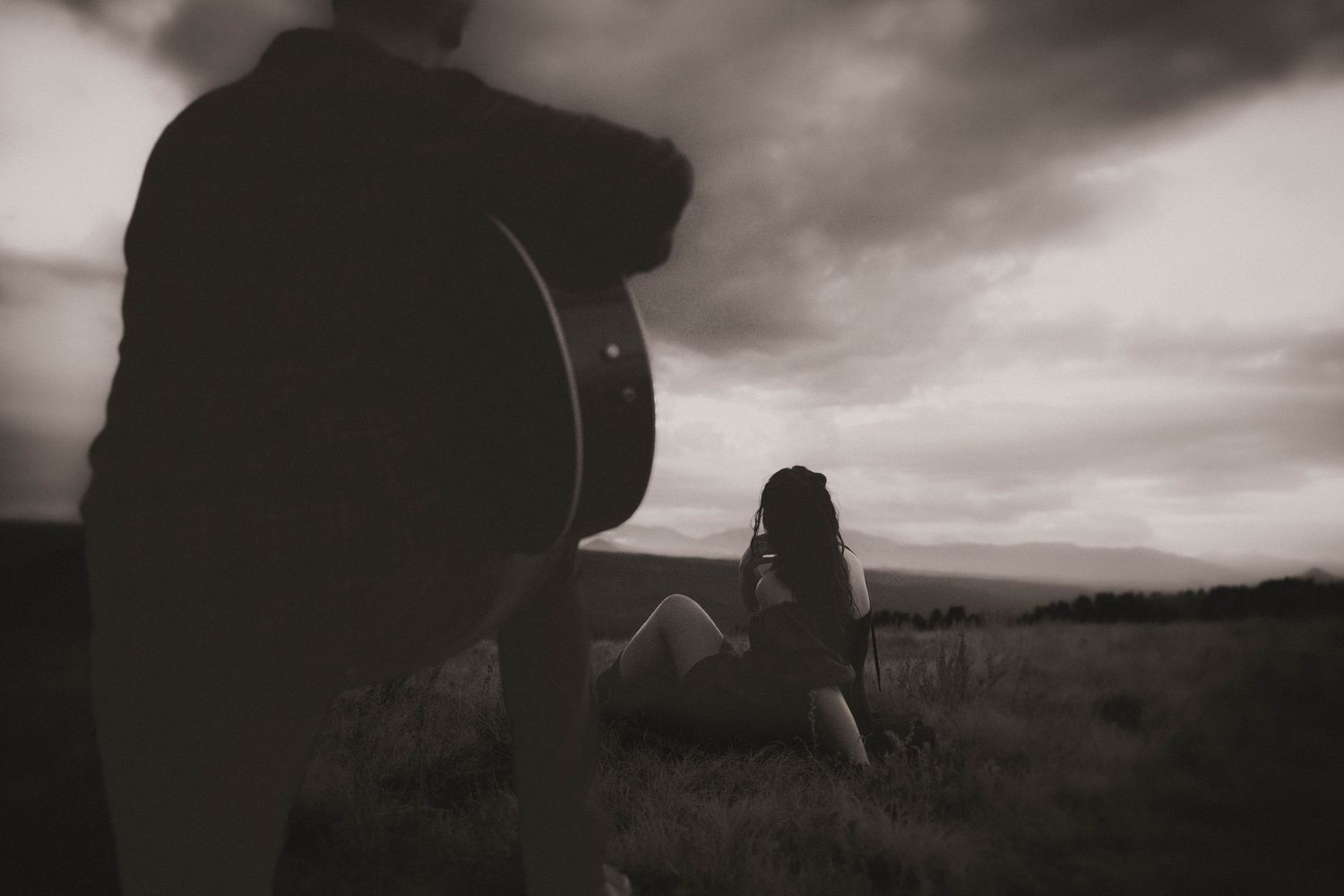 A quiet evening unfolds, music drifts through the hills as love lingers in the stillness, two souls wrapped in song and sky.