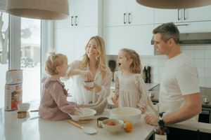 A loving family enjoying breakfast together at a bright white kitchen counter on a sunny morning.