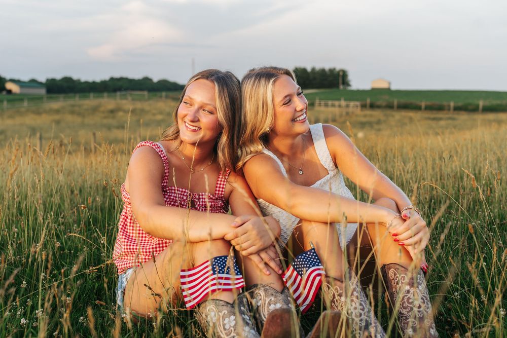 Friends lounging together in a summer field with American flag decorations.