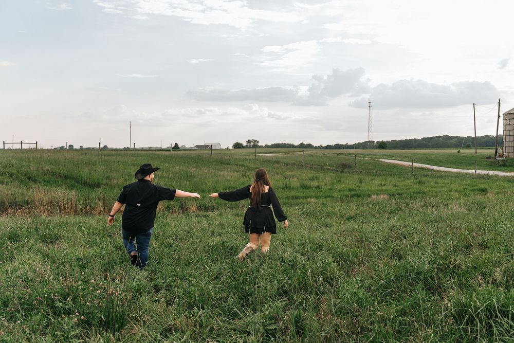 People enjoying a carefree moment in a grassy field against a cloudy sky.