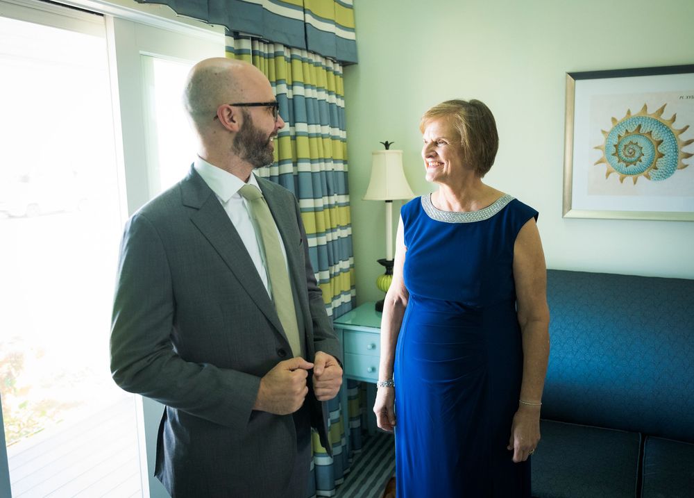 Wedding day preparation moment in hotel room with blue curtains and decor.