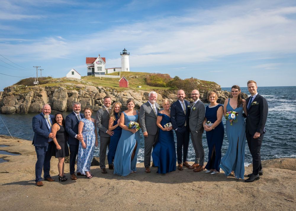 Wedding party group photo in front of Nubble Lighthouse in Maine.