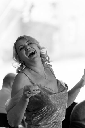 Candid black and white shots capture joyful laughter in sparkling formal attire.