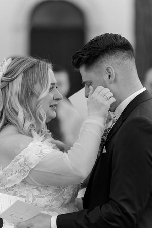 A touching black and white photo of newlyweds sharing an emotional moment.