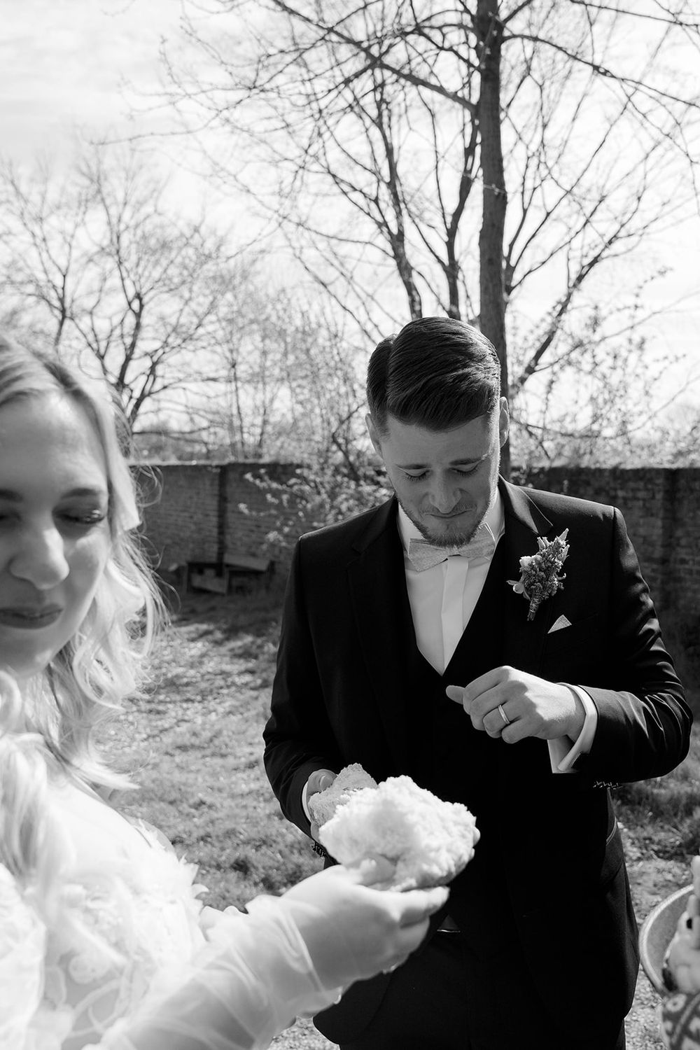 The newlyweds share cake during a playful moment at their wedding reception.