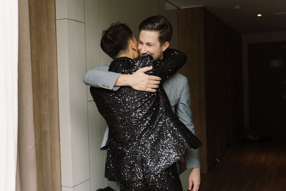 Candid moments captured in low light showing sparkly formal attire.