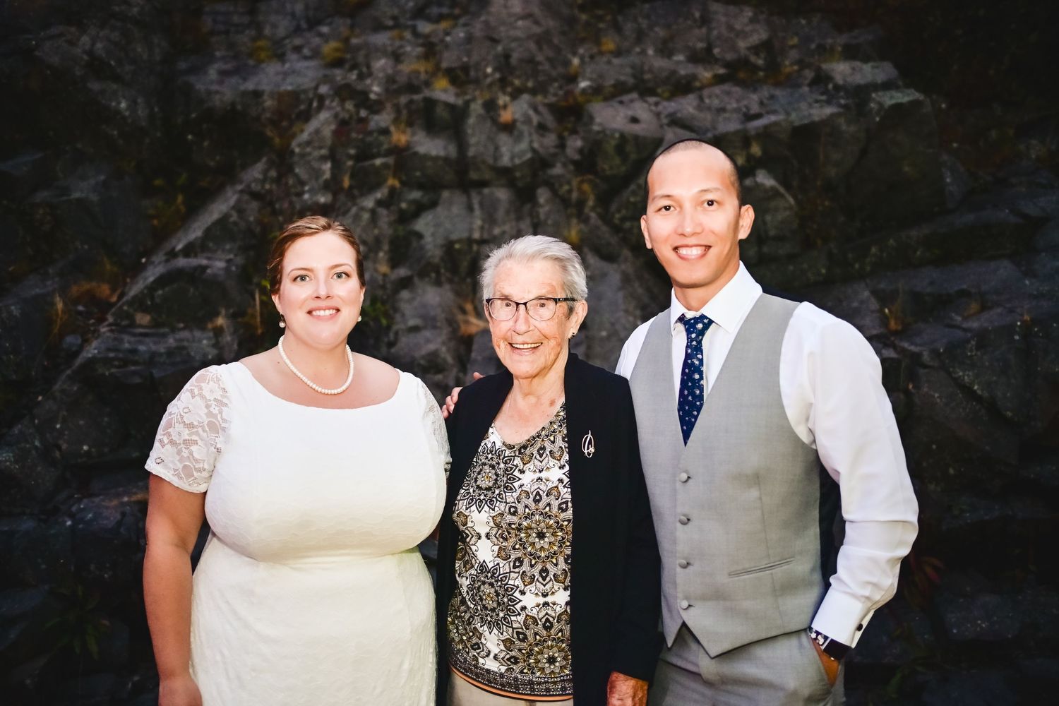 Grandmother posing with her newly married granddaughter and groom during the wedding reception, Newfoundland.