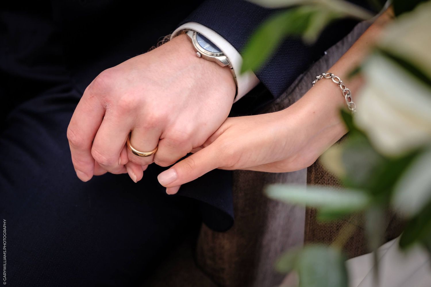 Close-up photo of hands holding a pen while signing a document during a formal ceremony.