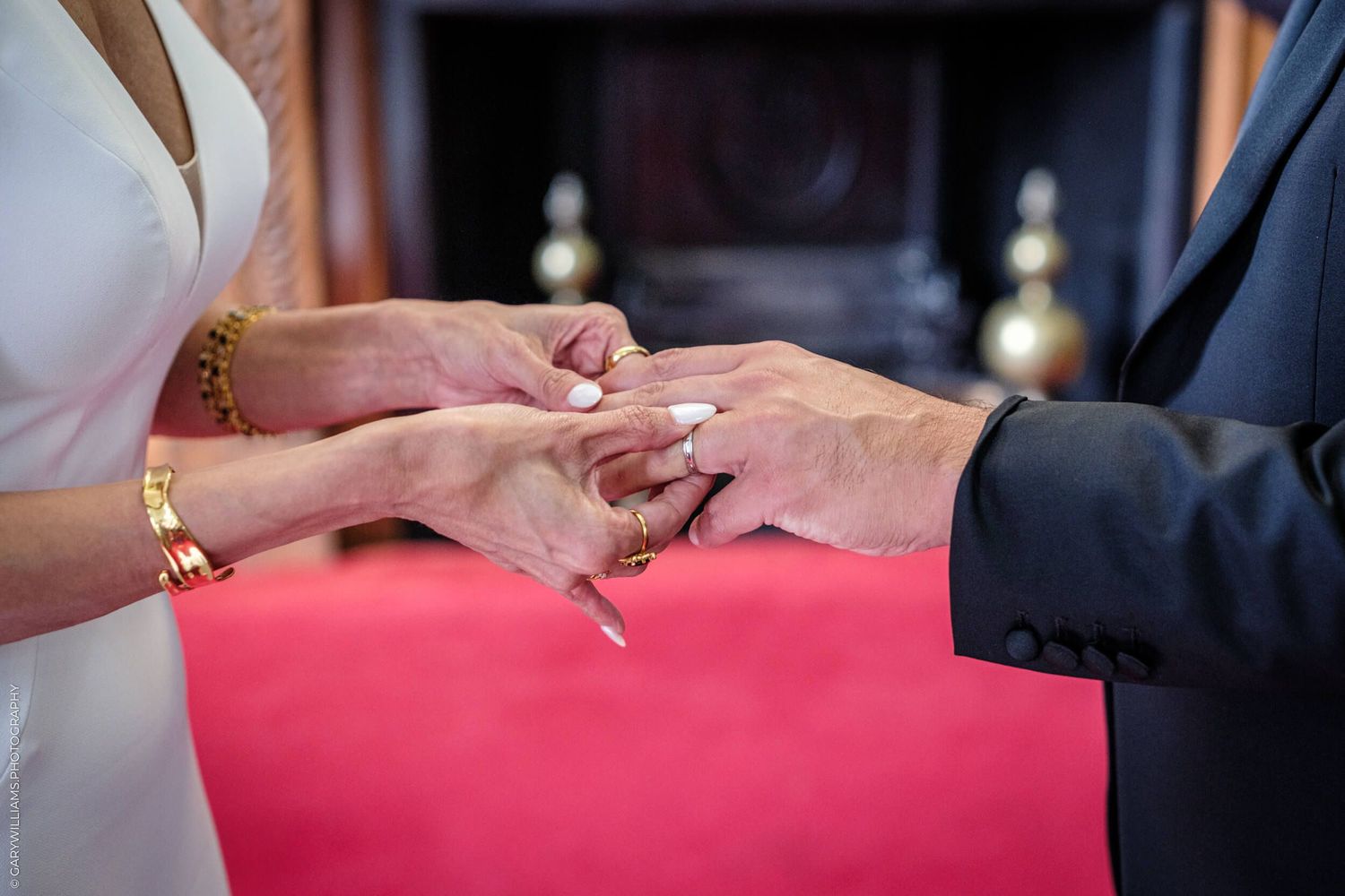 Multiple hands reach towards a pink surface during what appears to be a signing ceremony.
