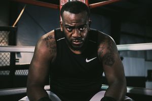 Athletic figure working out in dark gym environment wearing Nike apparel.