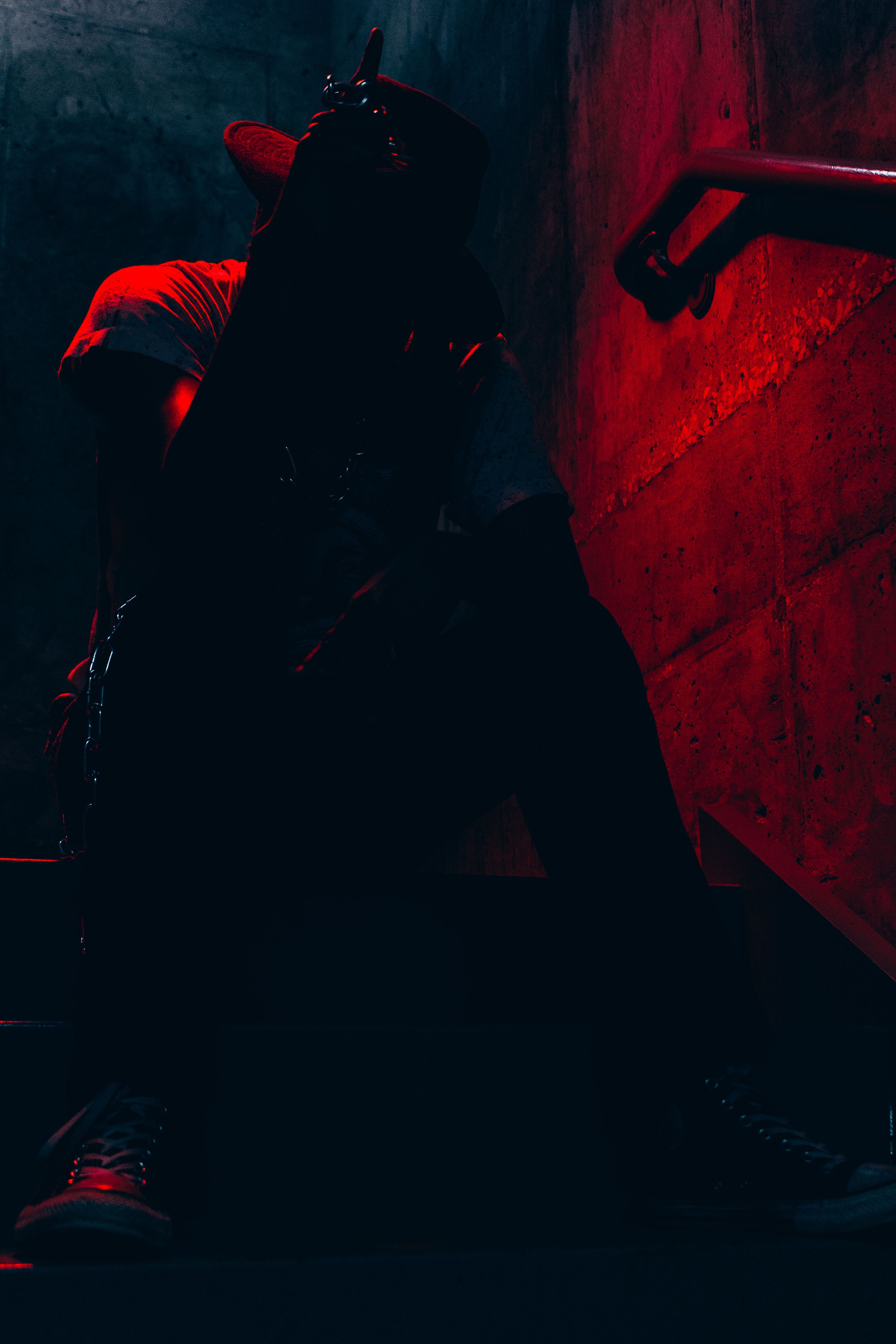 Abstract composition with deep red lighting and dark shadows creating mysterious shapes.