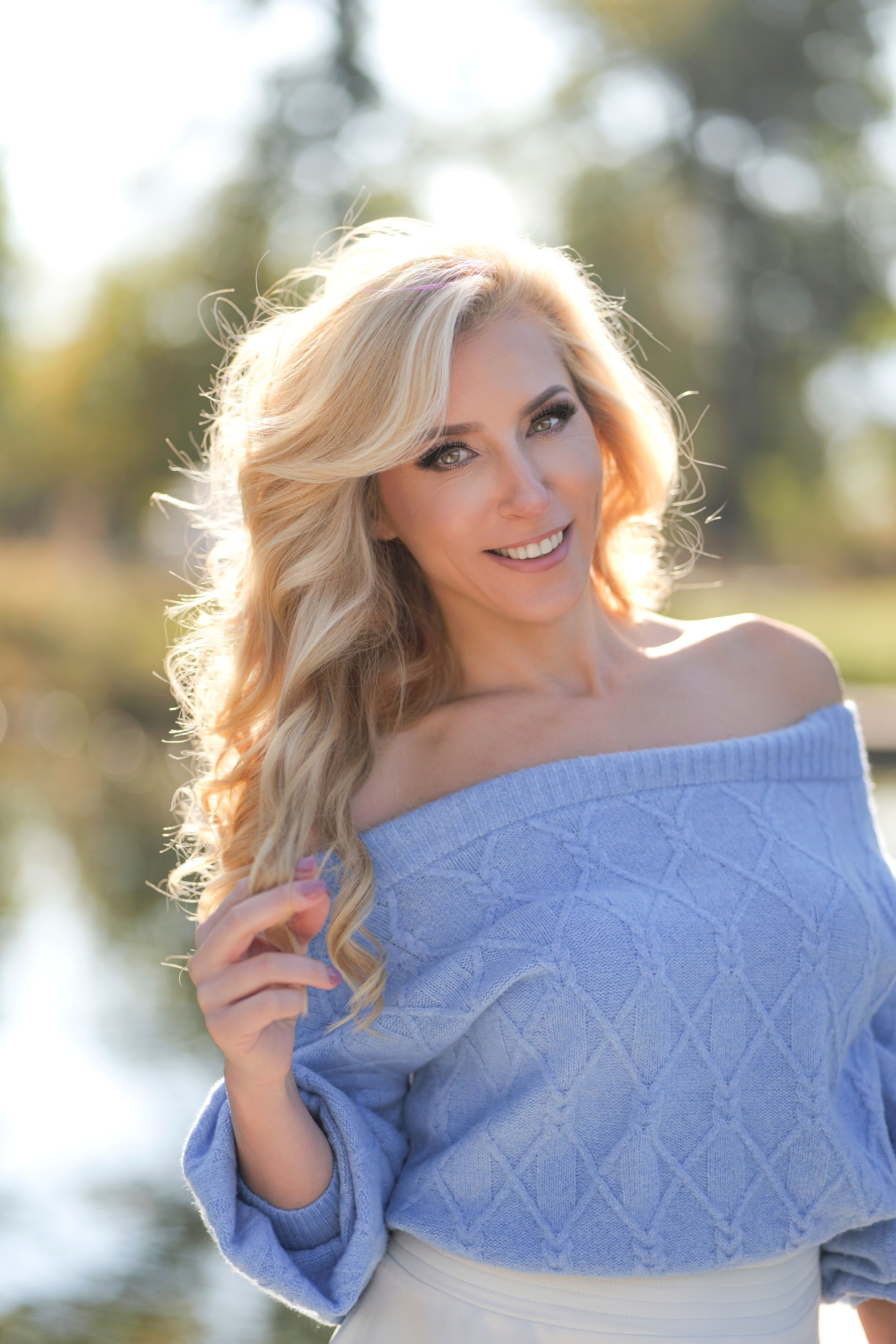 Portrait series featuring soft blue sweater and sun-lit outdoor setting.