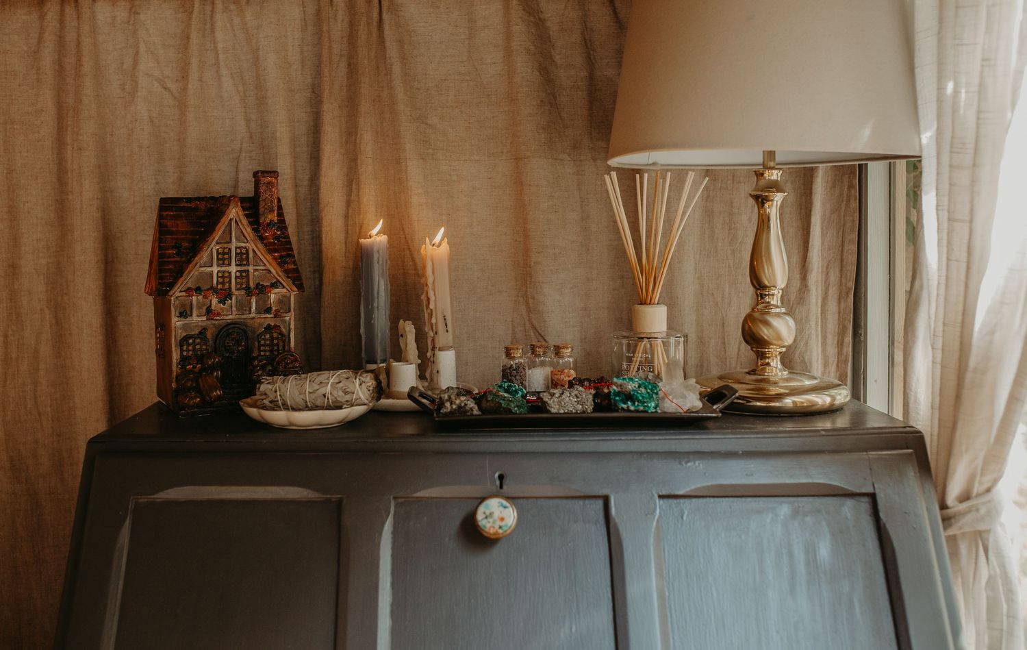 Rustic gray cabinets decorated with holiday ornaments and candles create an elegant Christmas display.