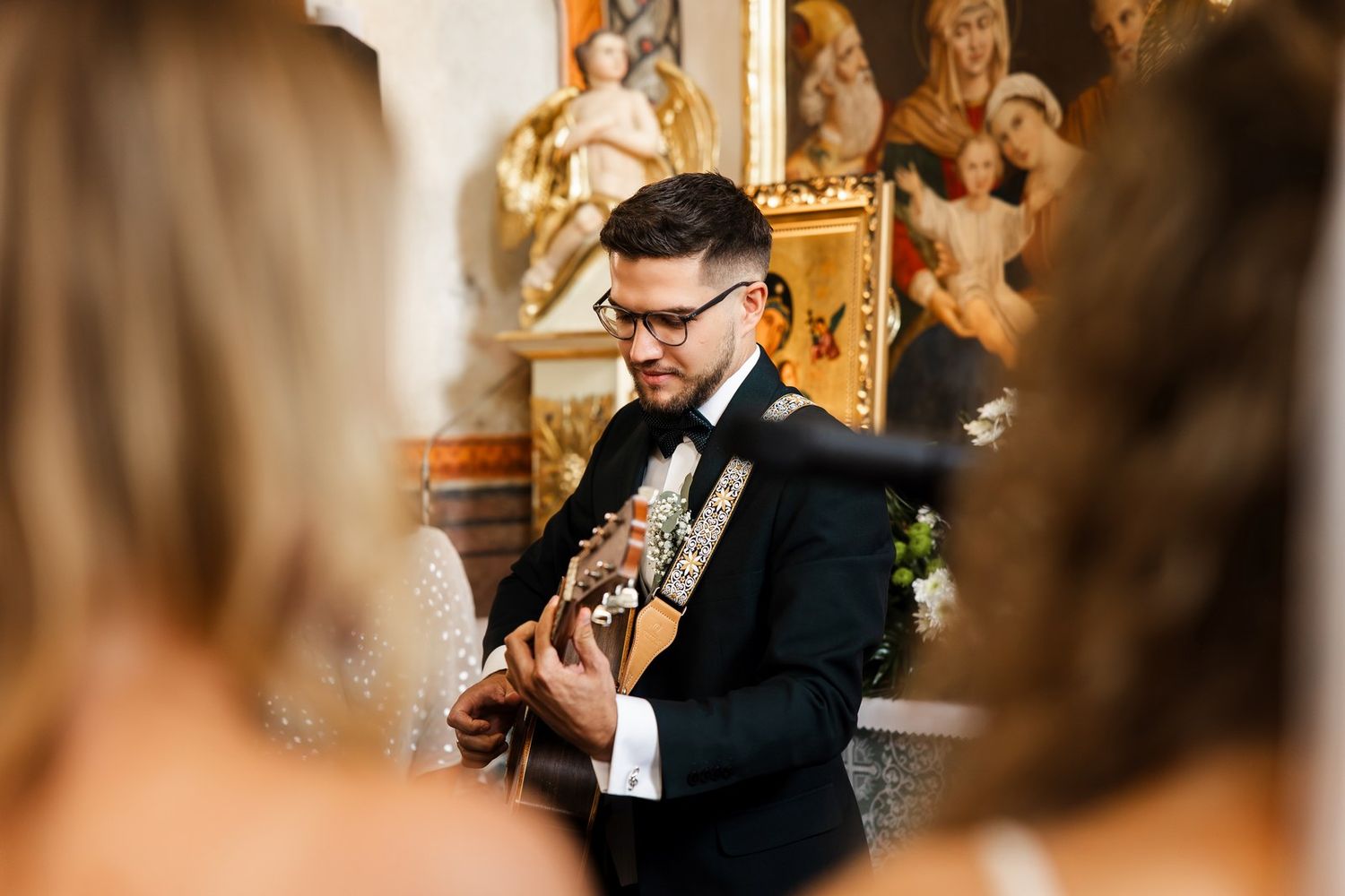 Pan młody gra na gitarze w kościele