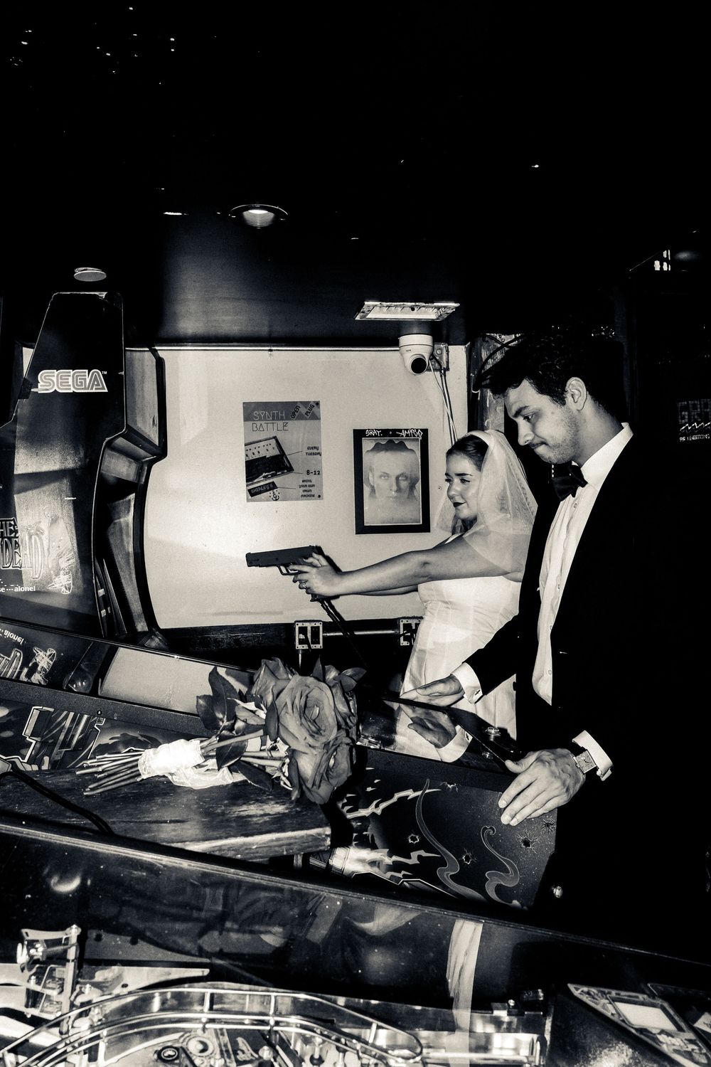 A series of vintage black and white photographs showing people working with pinball machines in a dark room setting.