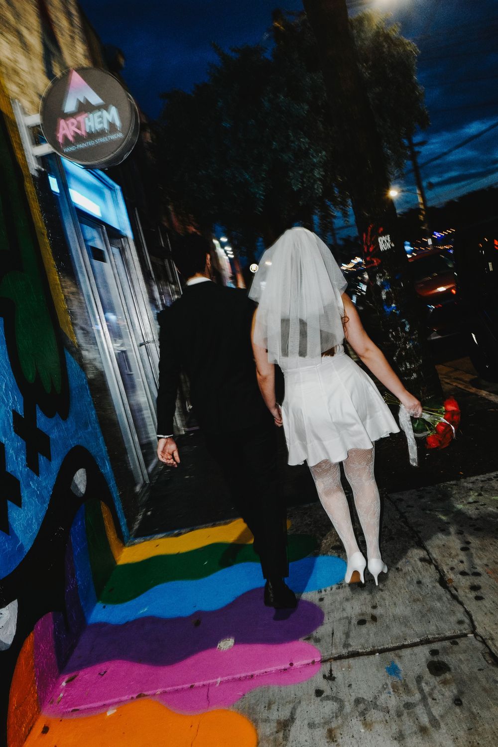 A series of sequential nighttime photos showing someone walking up colorful concrete steps with a flowing white dress.