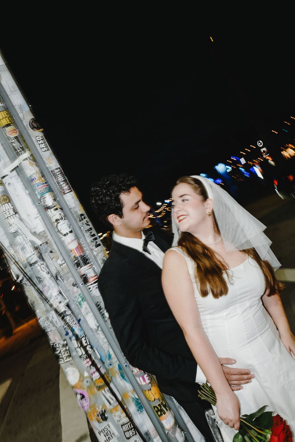 Romantic wedding couple sharing an intimate moment together under outdoor lighting while dancing at their reception.
