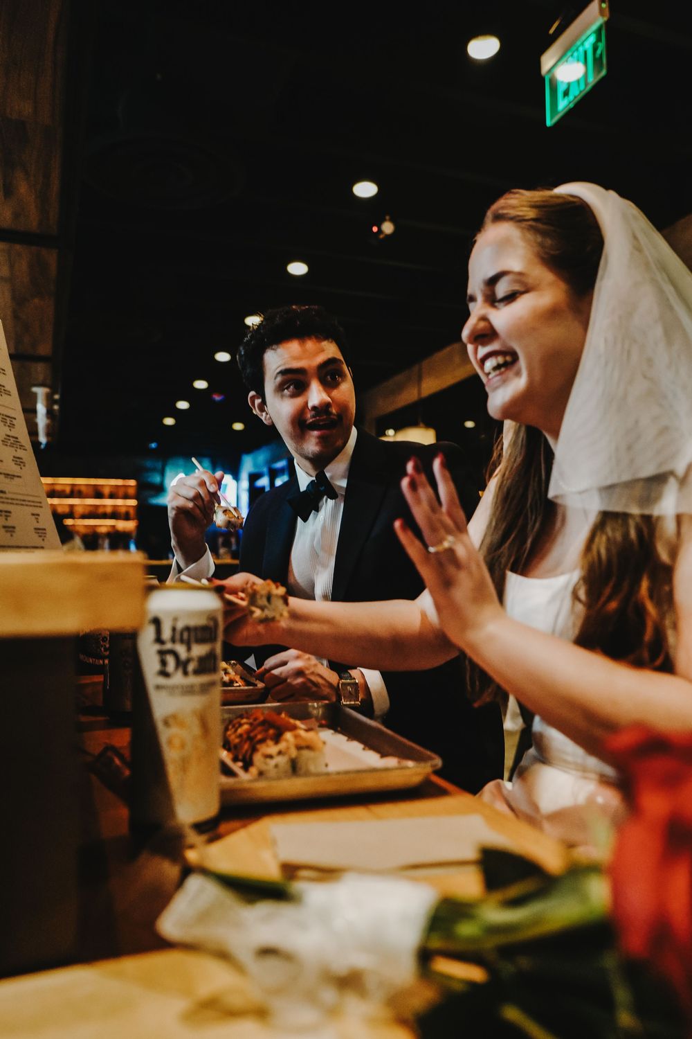 Wedding reception celebration showing laughter and joy shared during a casual dining moment in warm lighting.