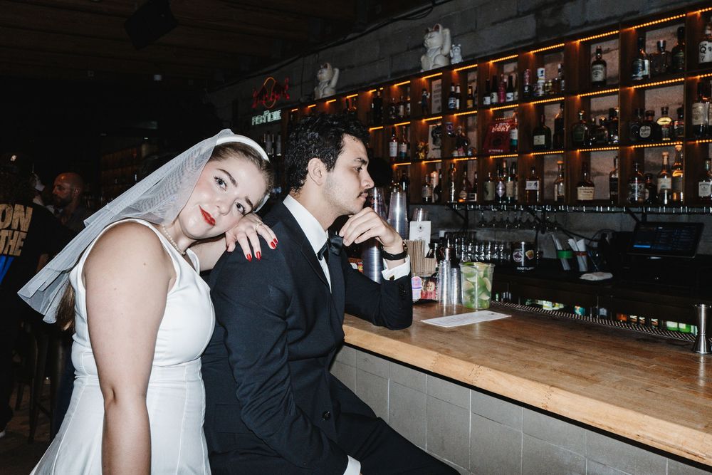 A couple shares intimate moments during their wedding celebration at a rustic barn venue with string lights overhead.