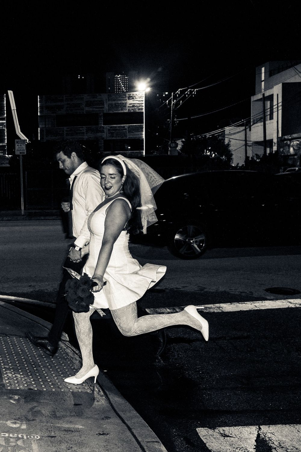 A dramatic black and white photo sequence shows a couple dancing energetically on a nighttime street corner.