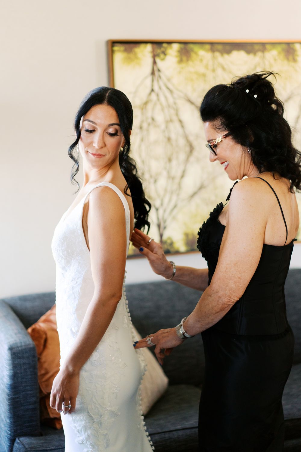 A series of wedding preparation photos showing final adjustments being made to a white wedding dress before the ceremony.