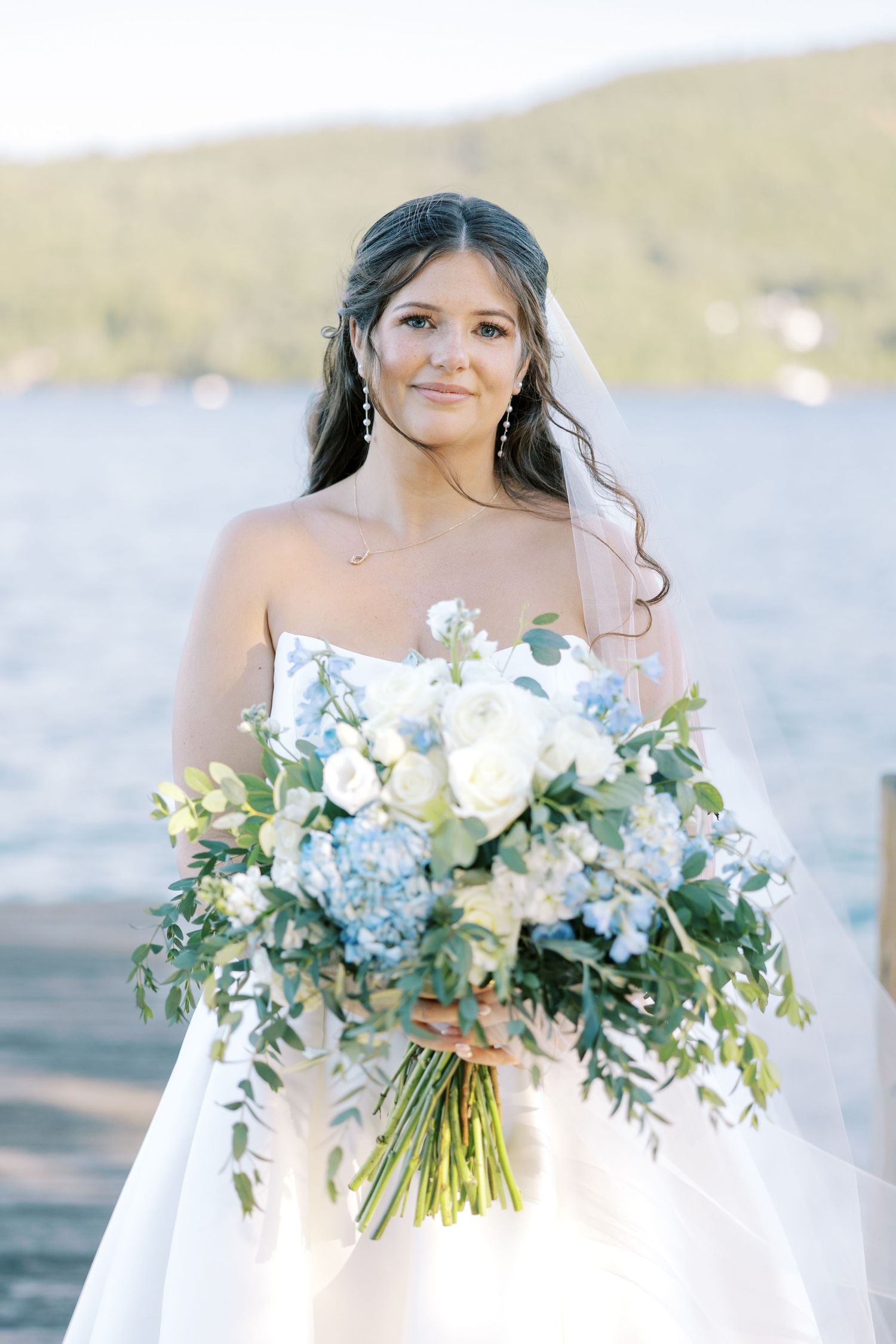 Ethereal bridal portrait series featuring a flowing white gown and lush bouquet with white roses and eucalyptus stems.