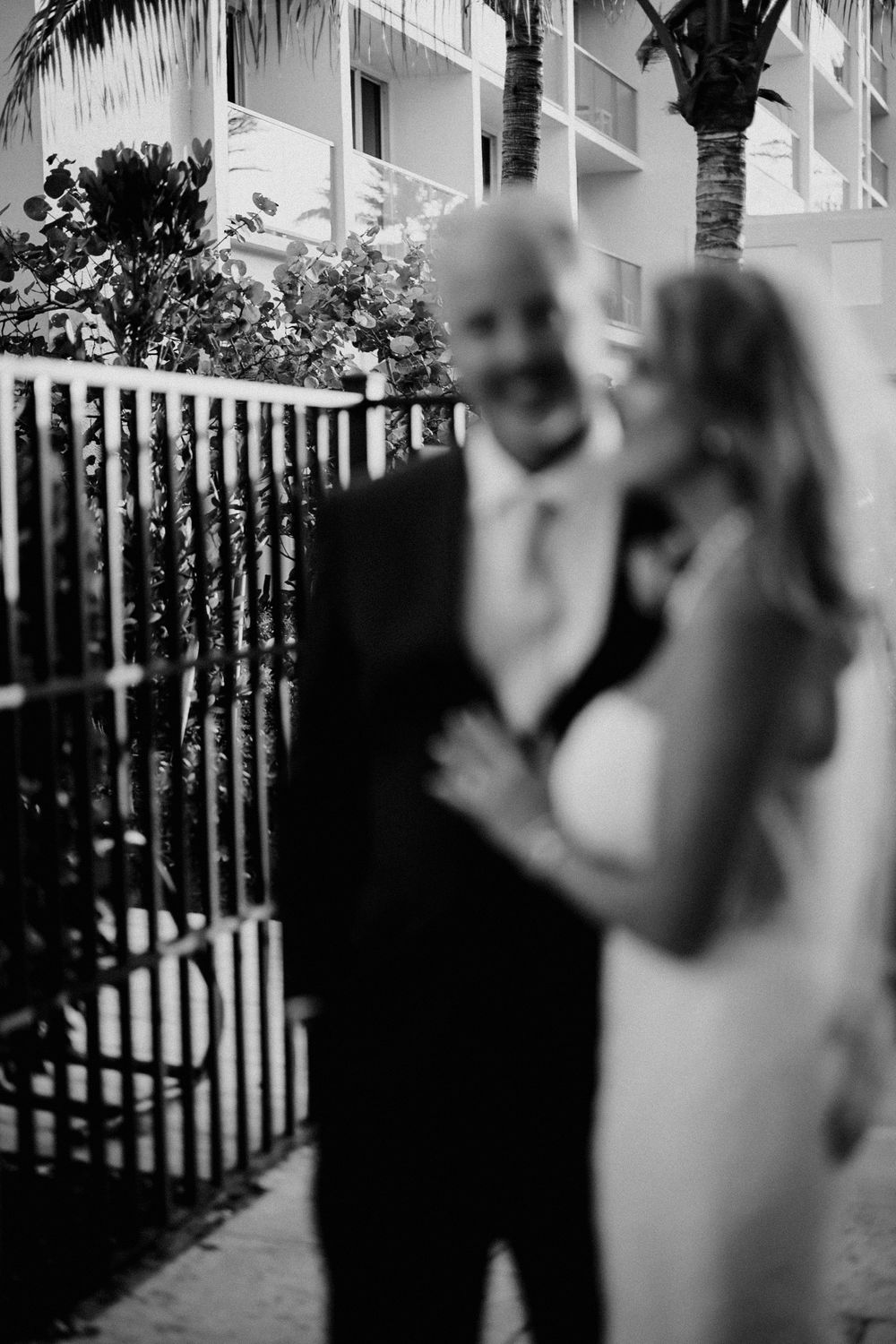 Black and white artistic wedding photos captured through decorative iron railings.